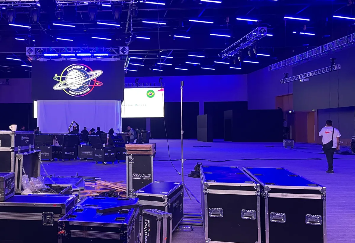 Nave de exposiciones en montaje, con truss, pantalla principal y road cases